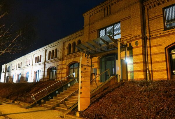 Gelbes Backsteingebäude bei Nacht (Behördensitz).