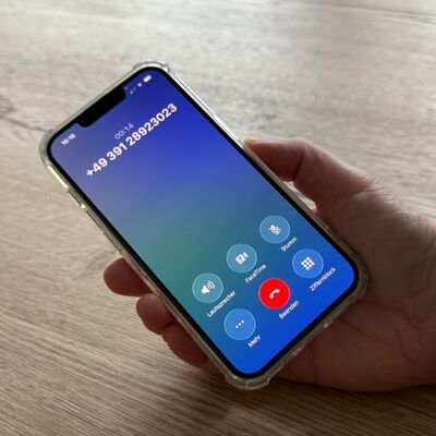 Hand hält Smartphone. Die Nummer der MLBF wurde gewählt.